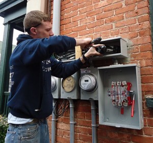 Electrician_installing_outdoor_connections_on_multifamily_house